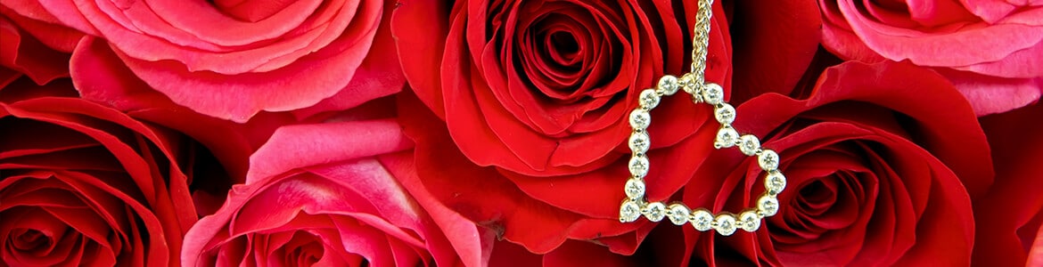 heart diamond pendant above a background of red roses